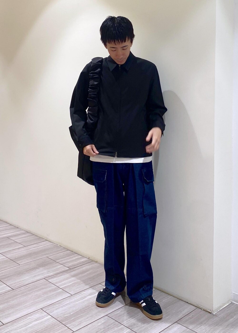 ブラック系のスニーカー、ブラック系のその他アウター、ブルー系のカーゴパンツを着用したメンズの秋コーディネートの3枚目の写真