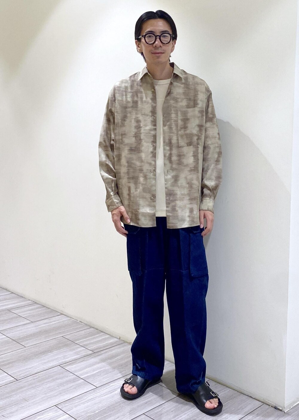 ブラック系のサンダル、ベージュ系のシャツ/ブラウス、ホワイト系のTシャツ/カットソーを着用したメンズの夏コーディネートの3枚目の写真