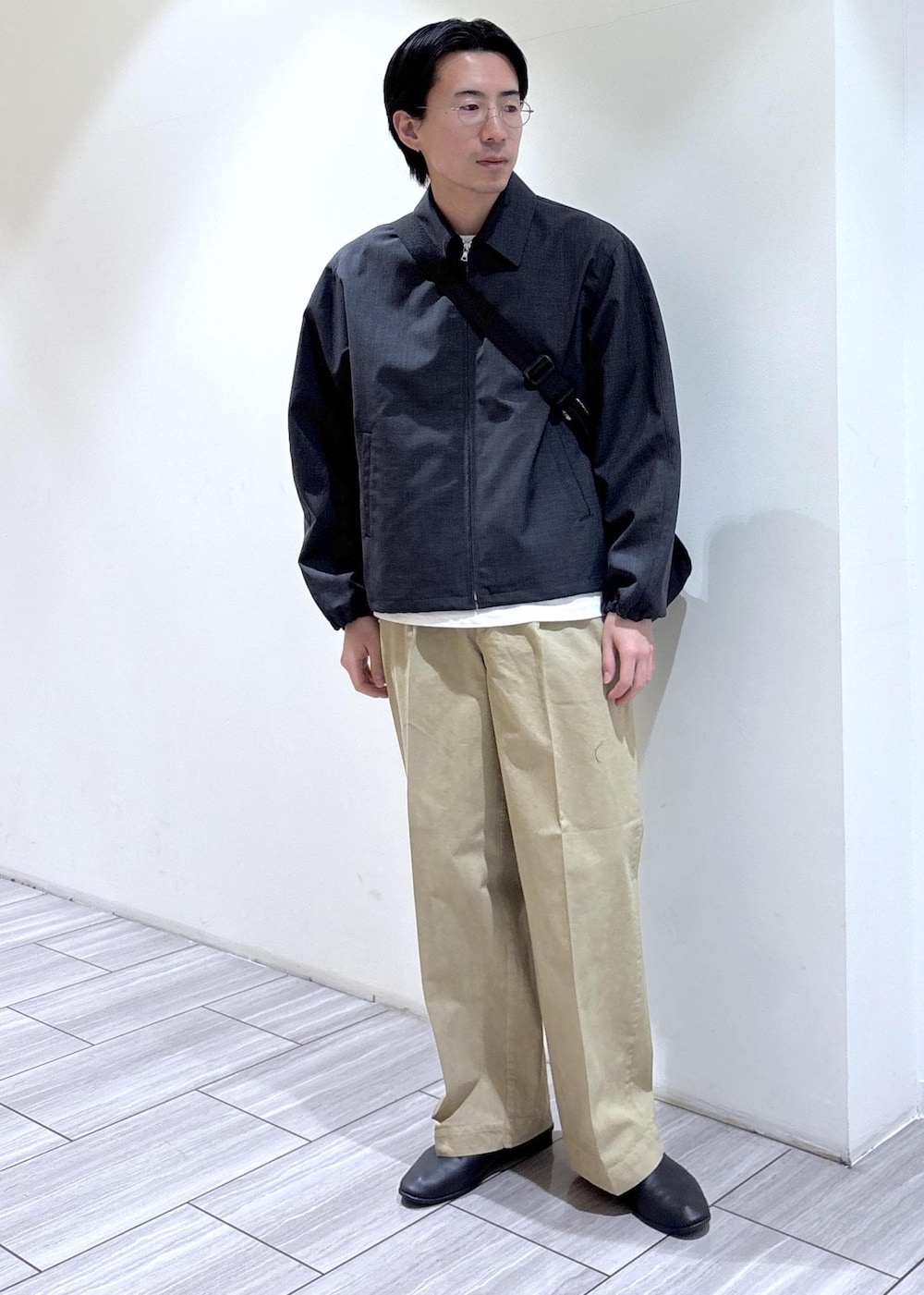 ブラック系のショルダーバッグ、グレー系のブルゾンを着用したメンズの春コーディネートの2枚目の写真