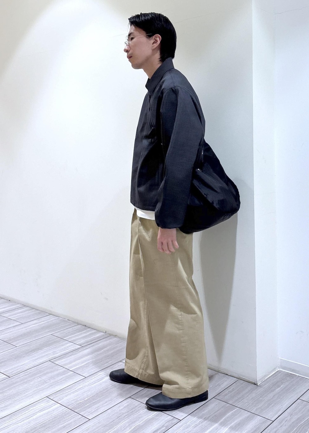 ブラック系のショルダーバッグ、グレー系のブルゾンを着用したメンズの春コーディネートの3枚目の写真