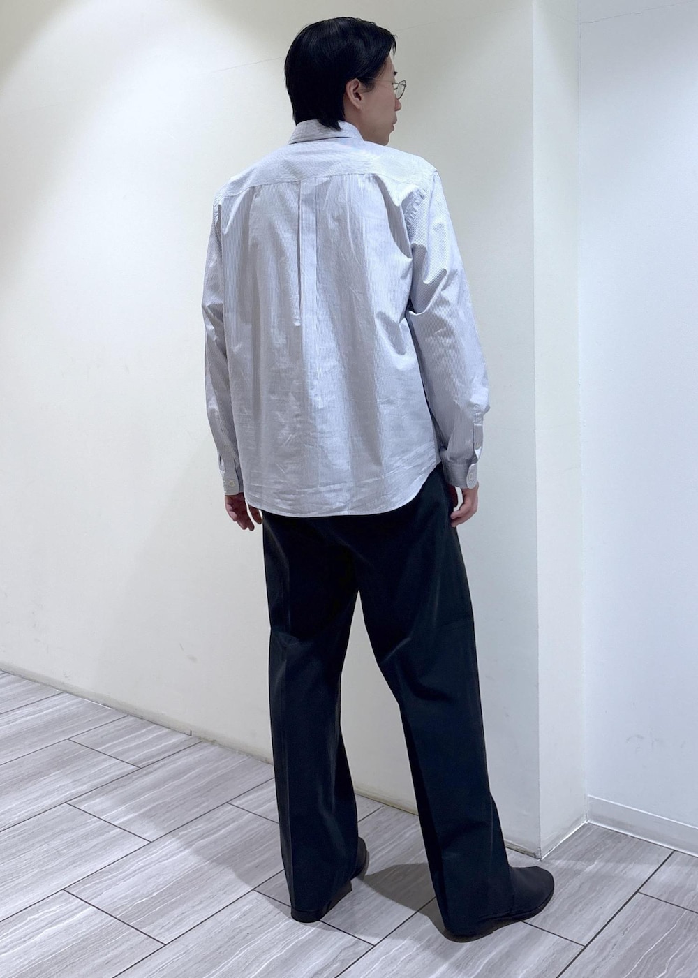 ブラック系のスラックス、ホワイト系のシャツ/ブラウスを着用したメンズの春コーディネートの4枚目の写真