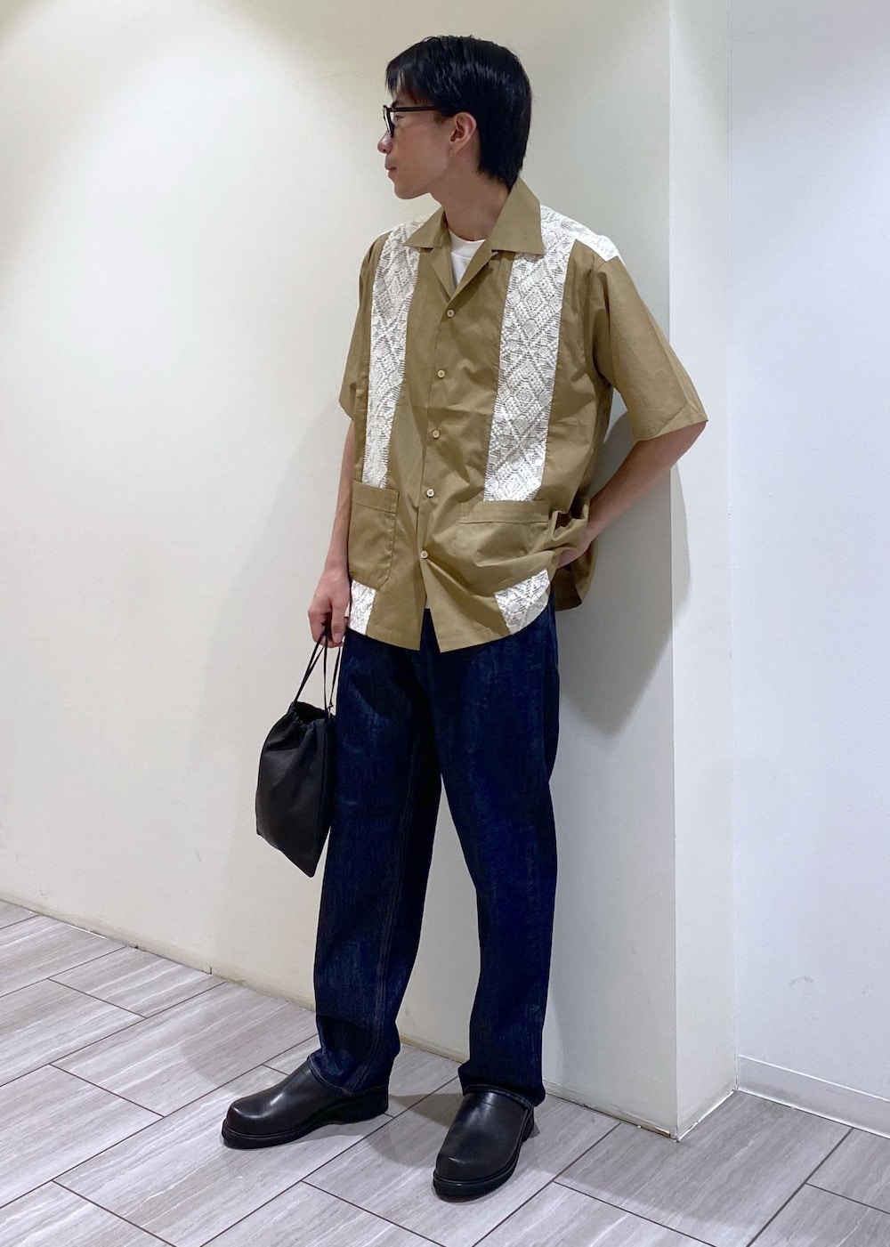 ベージュ系のTシャツ/カットソー、ブルー系のデニムパンツを着用したメンズの夏コーディネートの3枚目の写真