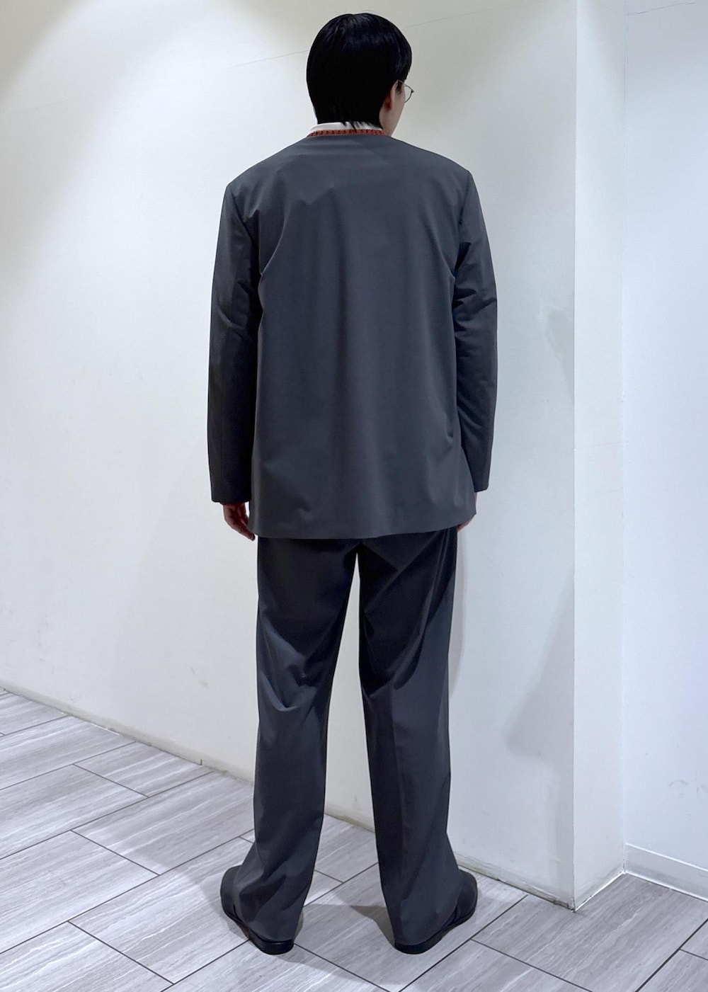 グレー系のノーカラージャケット、ホワイト系のシャツ/ブラウス、グレー系のスラックスを着用したメンズの冬コーディネートの4枚目の写真