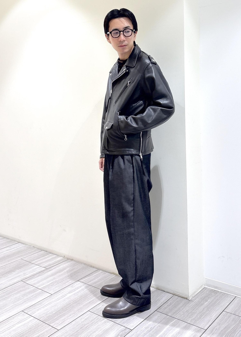 ブラック系のデニムパンツ、ブラウン系のTシャツ/カットソー、ブラック系のライダースジャケットを着用したメンズの秋コーディネートの3枚目の写真