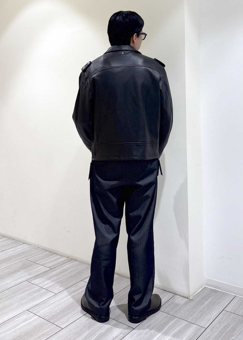 ブラック系のデニムパンツ、ブラウン系のTシャツ/カットソー、ブラック系のライダースジャケットを着用したメンズの秋コーディネートの4枚目の写真