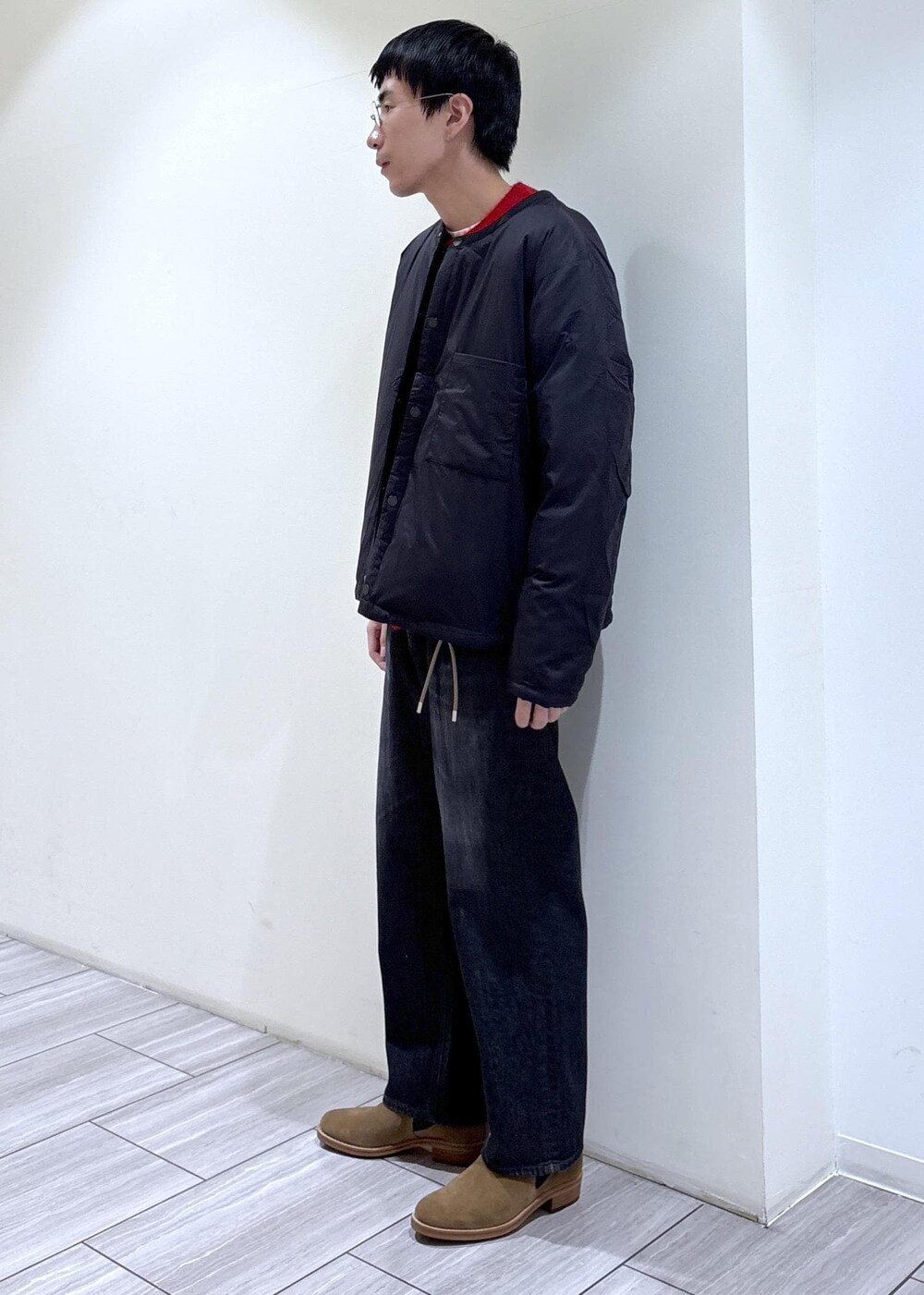 レッド系のカーディガン/ボレロ、ブラック系のダウンジャケット/コート、ブラック系のデニムパンツを着用したメンズの冬コーディネートの2枚目の写真