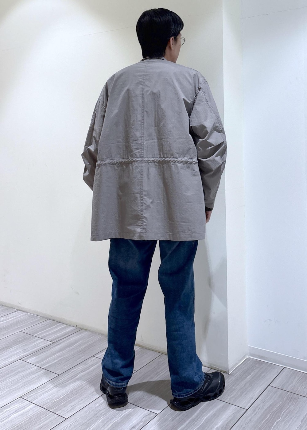 グリーン系のカーディガン/ボレロ、ブルー系のデニムパンツ、グレー系のモッズコートを着用したメンズの冬コーディネートの4枚目の写真