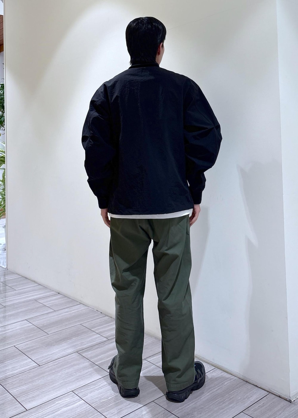 グリーン系のその他パンツ、グレー系のブルゾン、ホワイト系のTシャツ/カットソーを着用したメンズの春コーディネートの3枚目の写真