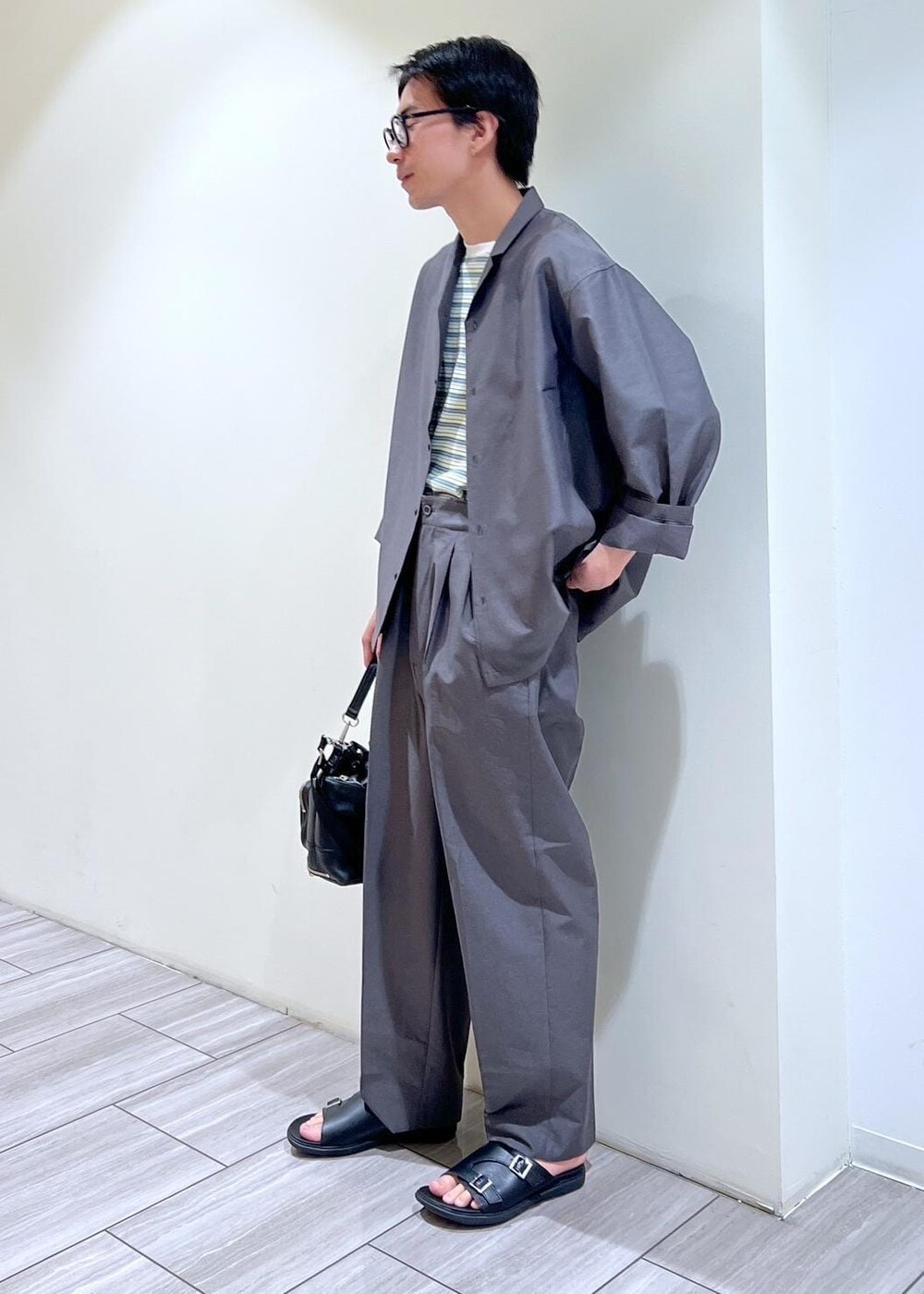 グレー系のシャツ/ブラウス、グレー系のスラックスを着用したメンズの夏コーディネートの4枚目の写真