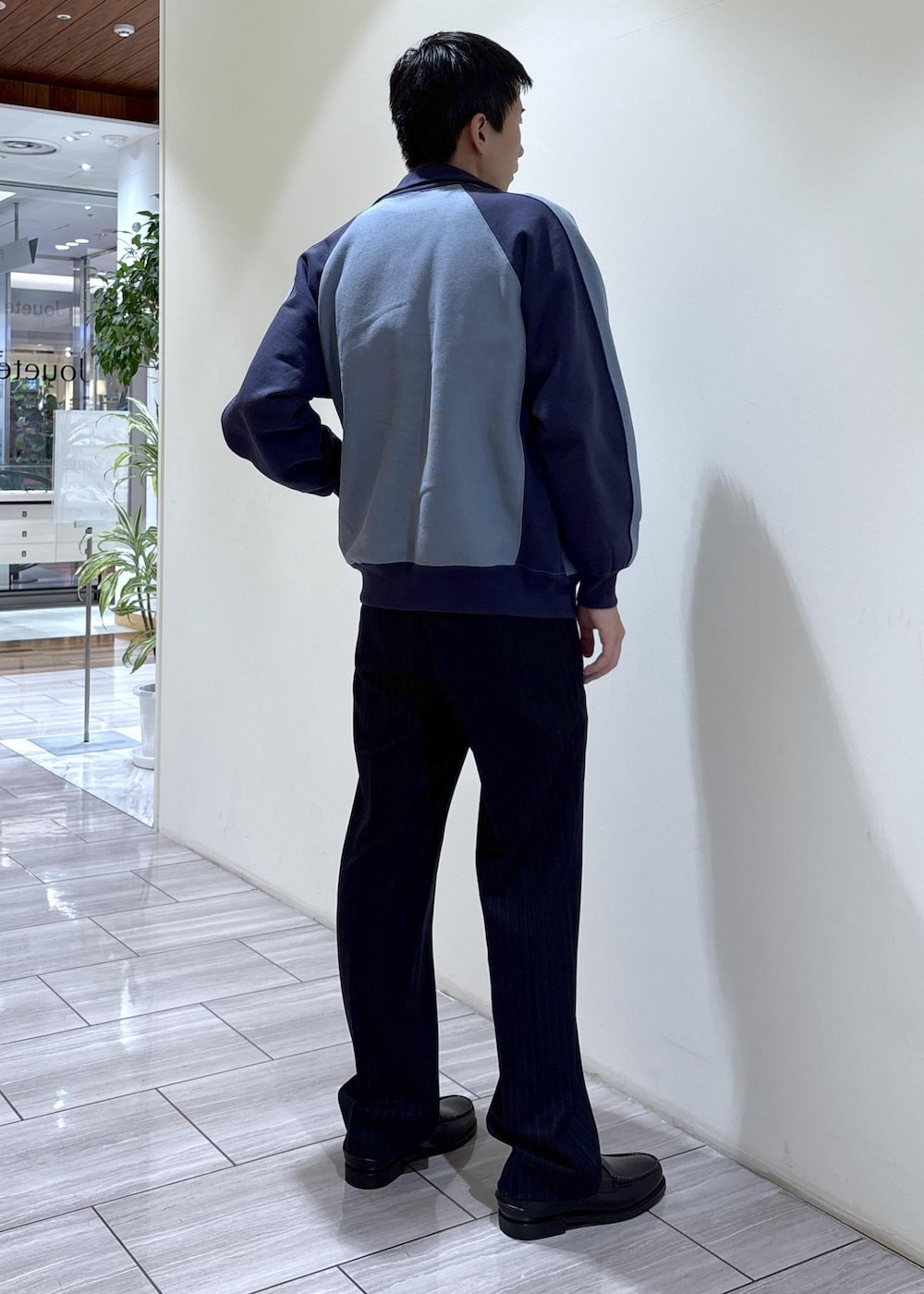 ブラック系のスリッポン、ブルー系のカーディガン/ボレロ、ブルー系のスラックスを着用したメンズの秋コーディネートの4枚目の写真