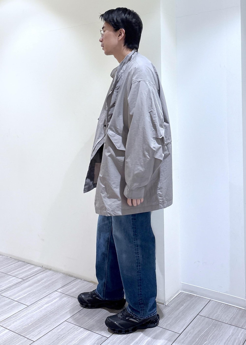 グリーン系のカーディガン/ボレロ、ブルー系のデニムパンツ、グレー系のモッズコートを着用したメンズの冬コーディネートの3枚目の写真