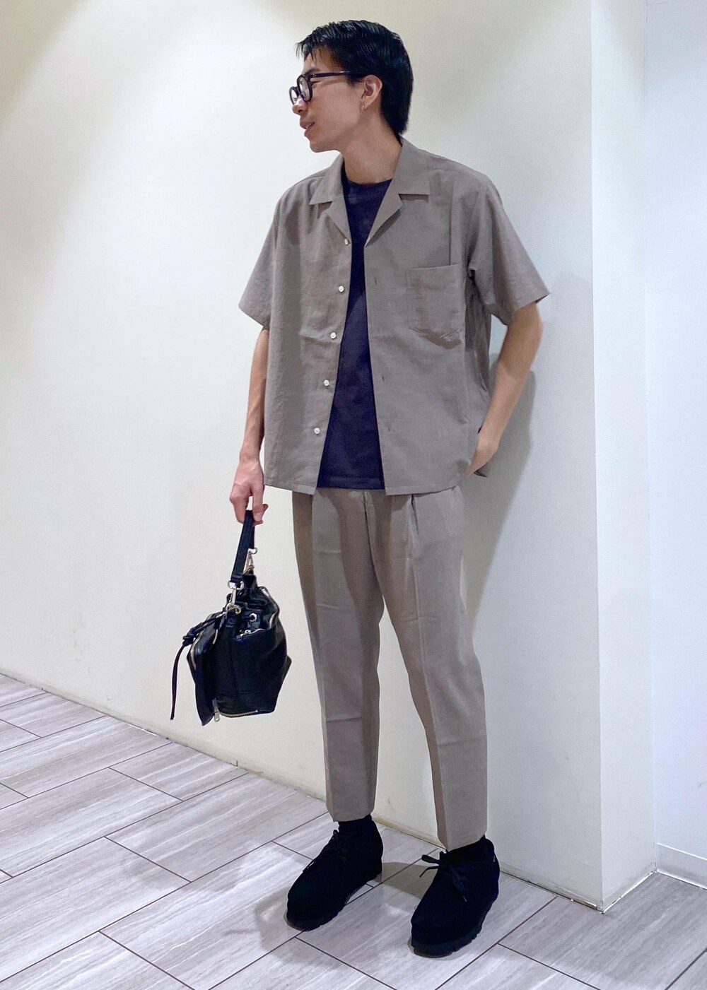 ベージュ系のセットアップ、ブラック系のTシャツ/カットソー、ブラック系のブーツを着用したメンズの夏コーディネートの5枚目の写真