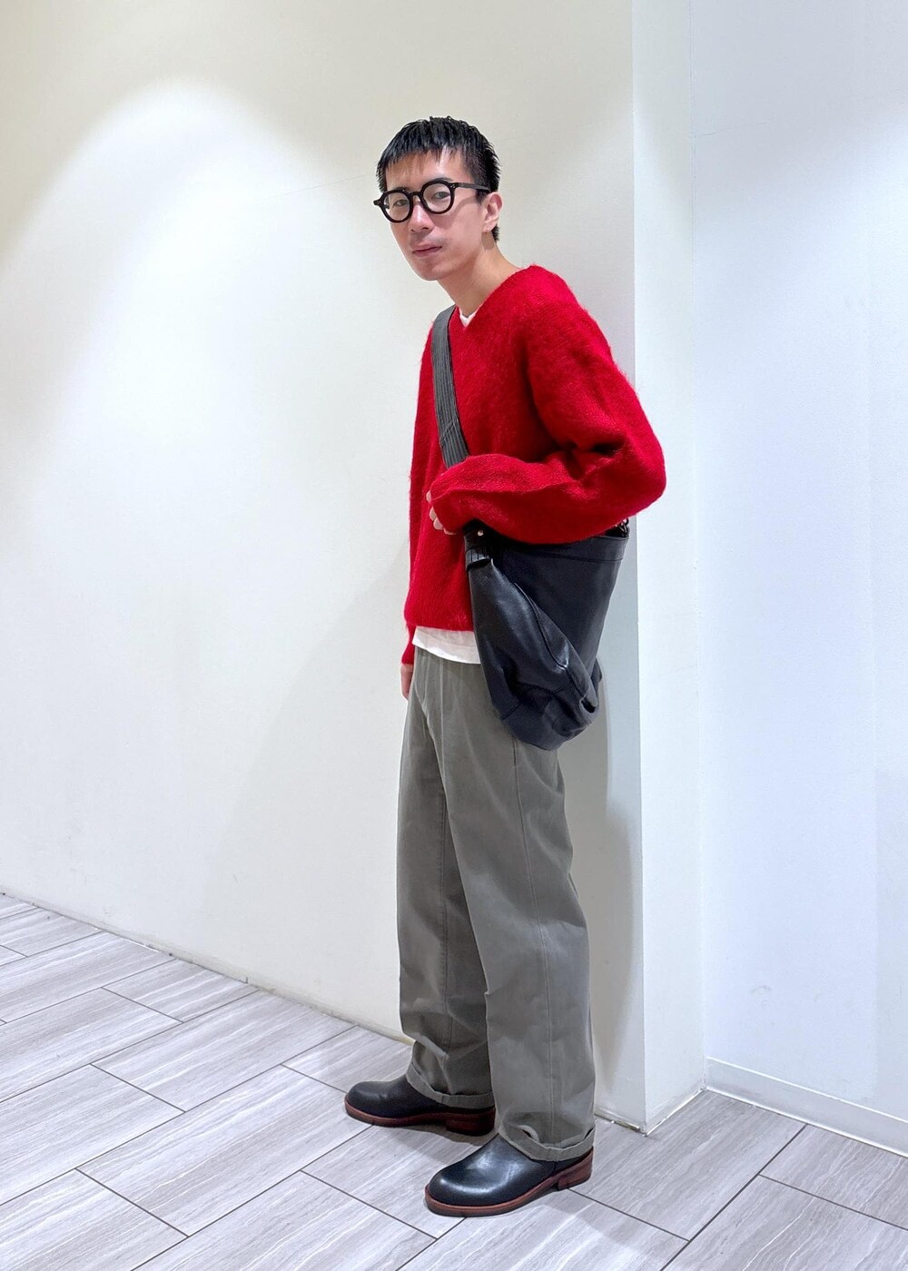 レッド系のニット/セーター、ブラック系のブーツ、グレー系のその他パンツを着用したメンズの秋コーディネートの2枚目の写真