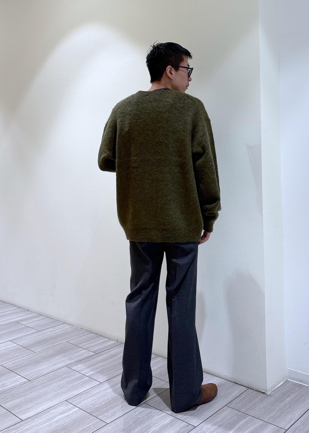 グリーン系のカーディガン/ボレロ、ブラウン系のスリッポン、グレー系のスラックスを着用したメンズの秋コーディネートの5枚目の写真