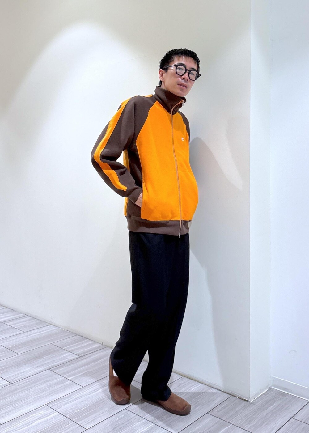 ブラウン系のカーディガン/ボレロ、ブラウン系のスリッポン、ブラック系のスラックスを着用したメンズの秋コーディネートの3枚目の写真