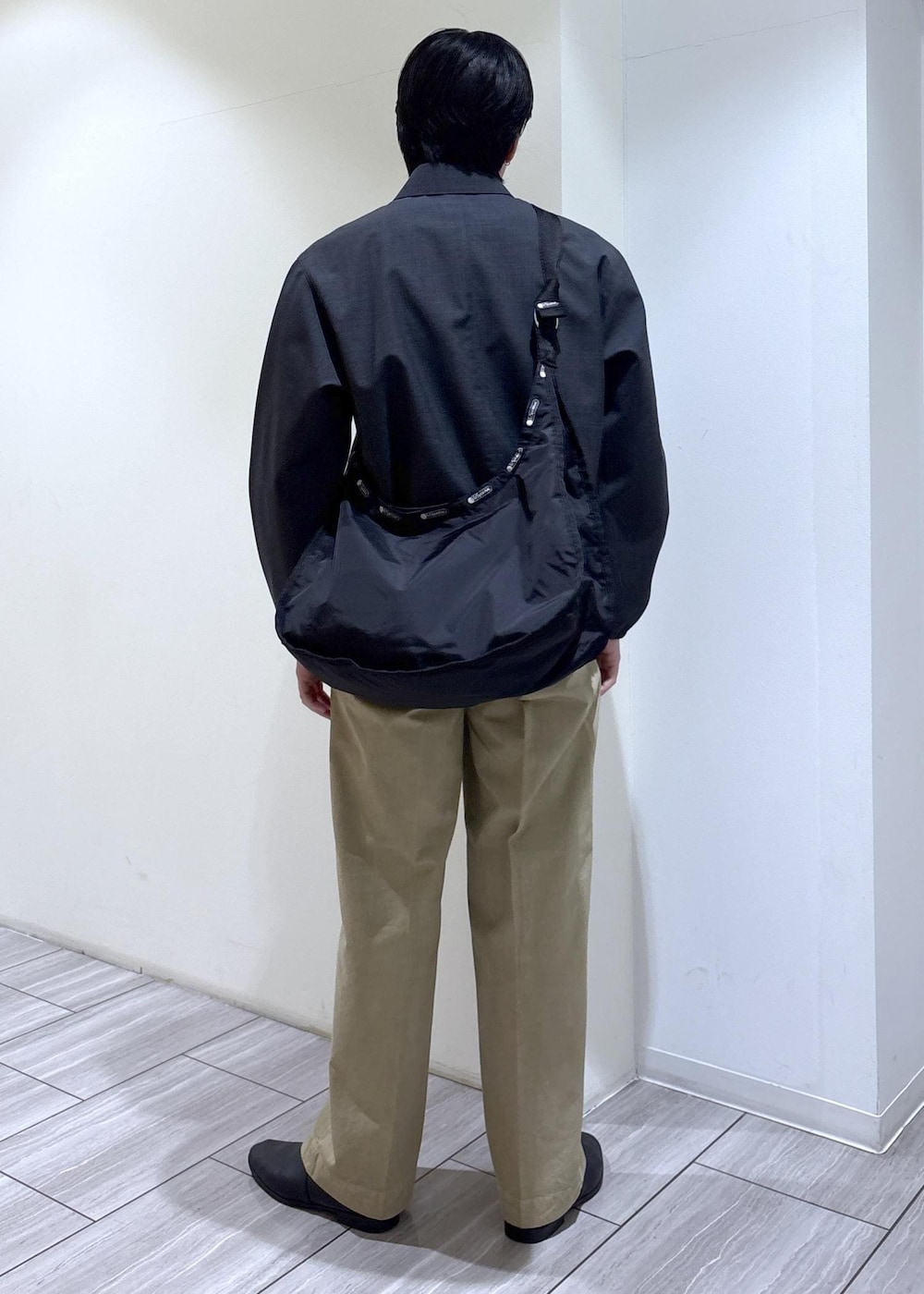 ブラック系のショルダーバッグ、グレー系のブルゾンを着用したメンズの春コーディネートの4枚目の写真