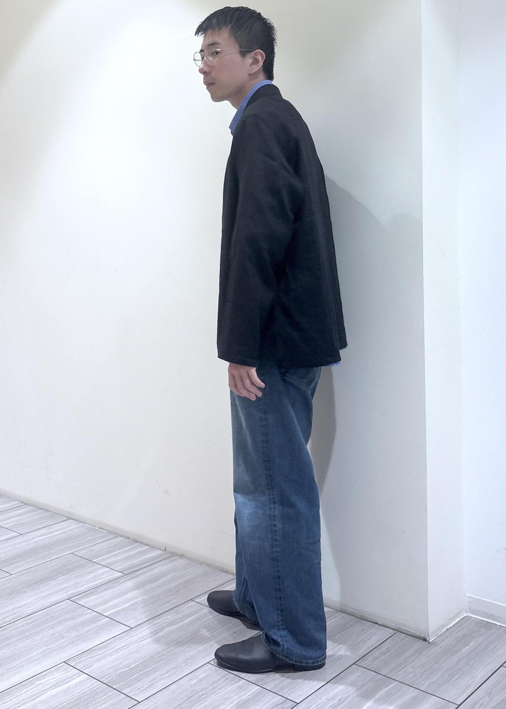 ブルー系のデニムパンツ、ブラック系のテーラードジャケットを着用したメンズの春コーディネートの2枚目の写真