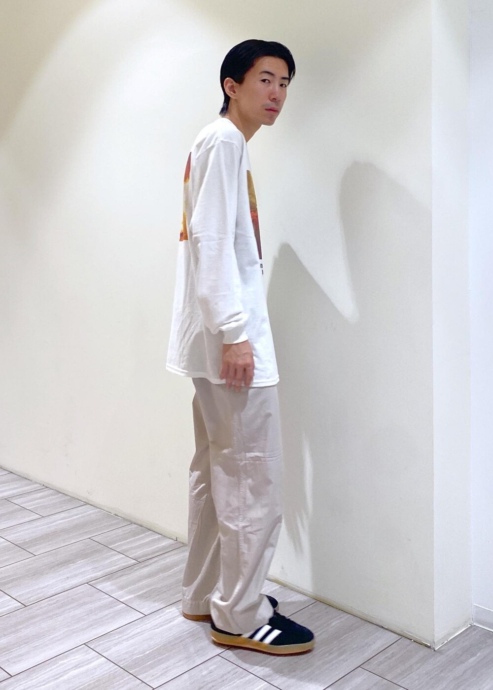 ブラック系のスニーカー、グレー系のカーゴパンツ、ホワイト系のTシャツ/カットソーを着用したメンズの夏コーディネートの2枚目の写真