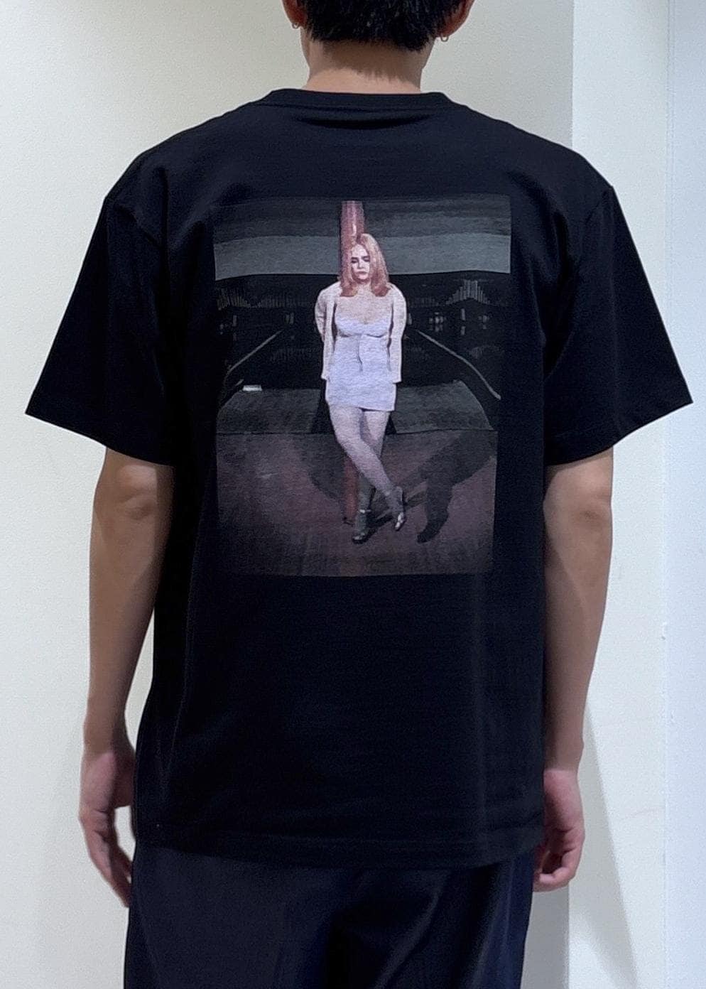 ブルー系のデニムパンツ、グレー系のTシャツ/カットソー、ベージュ系のトートバッグを着用したメンズの夏コーディネートの3枚目の写真