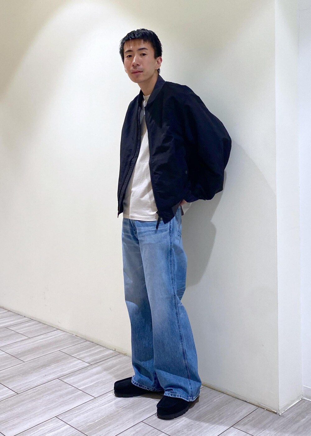 ブラック系のMA-1、ブルー系のデニムパンツ、グレー系のTシャツ/カットソーを着用したメンズの秋コーディネートの2枚目の写真