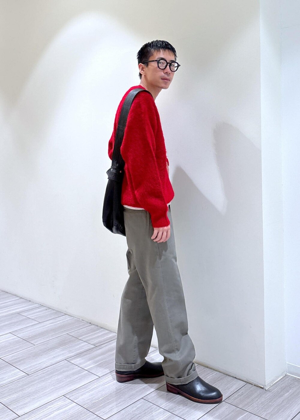 レッド系のニット/セーター、ブラック系のブーツ、グレー系のその他パンツを着用したメンズの秋コーディネートの3枚目の写真