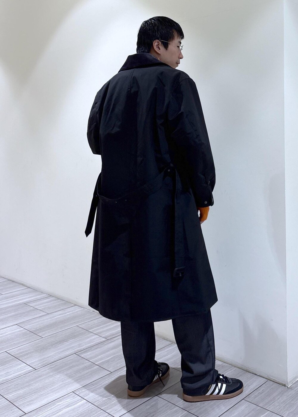ブラック系のトレンチコートを着用したメンズの秋コーディネートの3枚目の写真