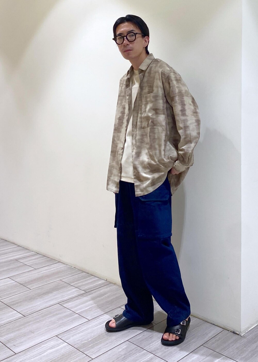 ブラック系のサンダル、ベージュ系のシャツ/ブラウス、ホワイト系のTシャツ/カットソーを着用したメンズの夏コーディネートの2枚目の写真