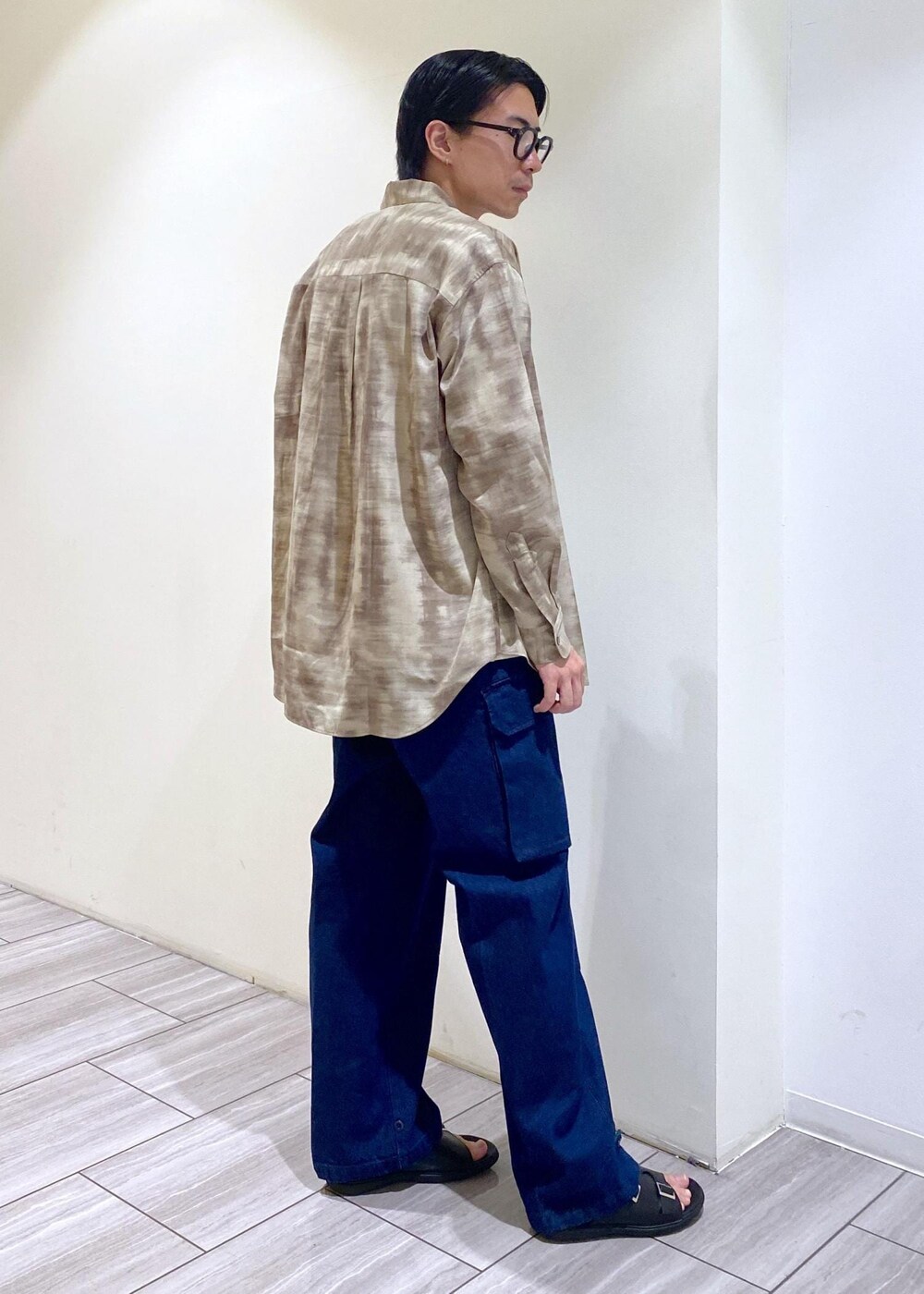 ブラック系のサンダル、ベージュ系のシャツ/ブラウス、ホワイト系のTシャツ/カットソーを着用したメンズの夏コーディネートの4枚目の写真