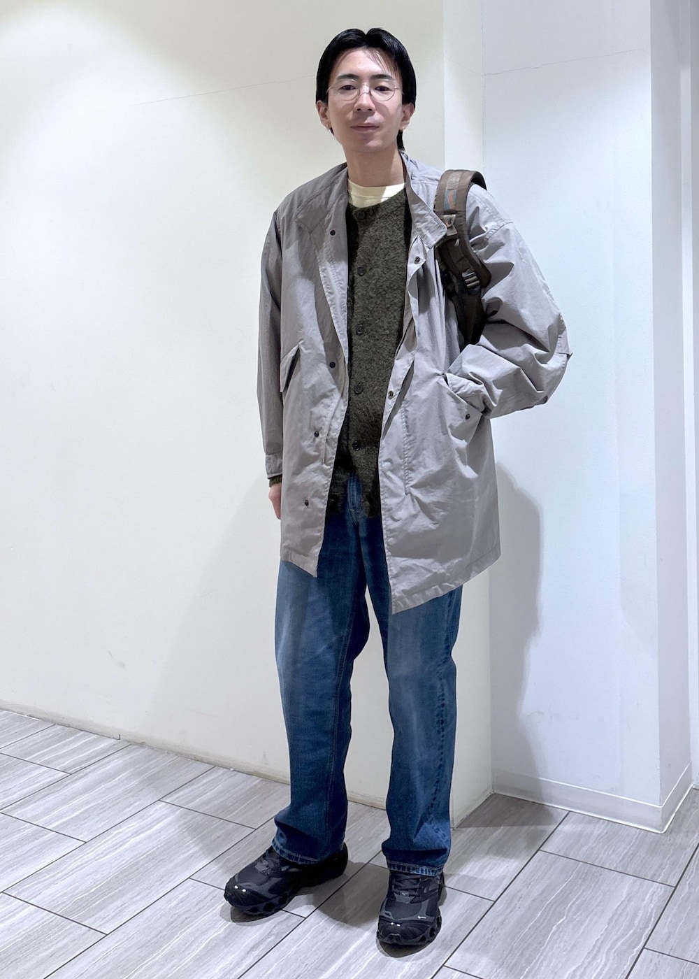 グリーン系のカーディガン/ボレロ、ブルー系のデニムパンツ、グレー系のモッズコートを着用したメンズの冬コーディネートの2枚目の写真