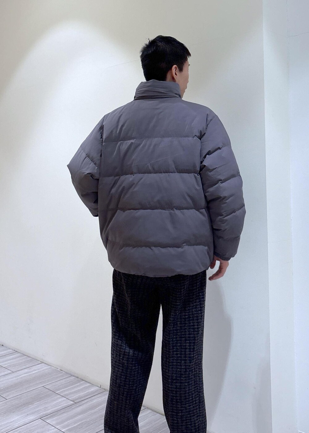 グレー系のダウンジャケット/コート、グレー系のスラックス、ブラウン系のブーツを着用したメンズの冬コーディネートの4枚目の写真