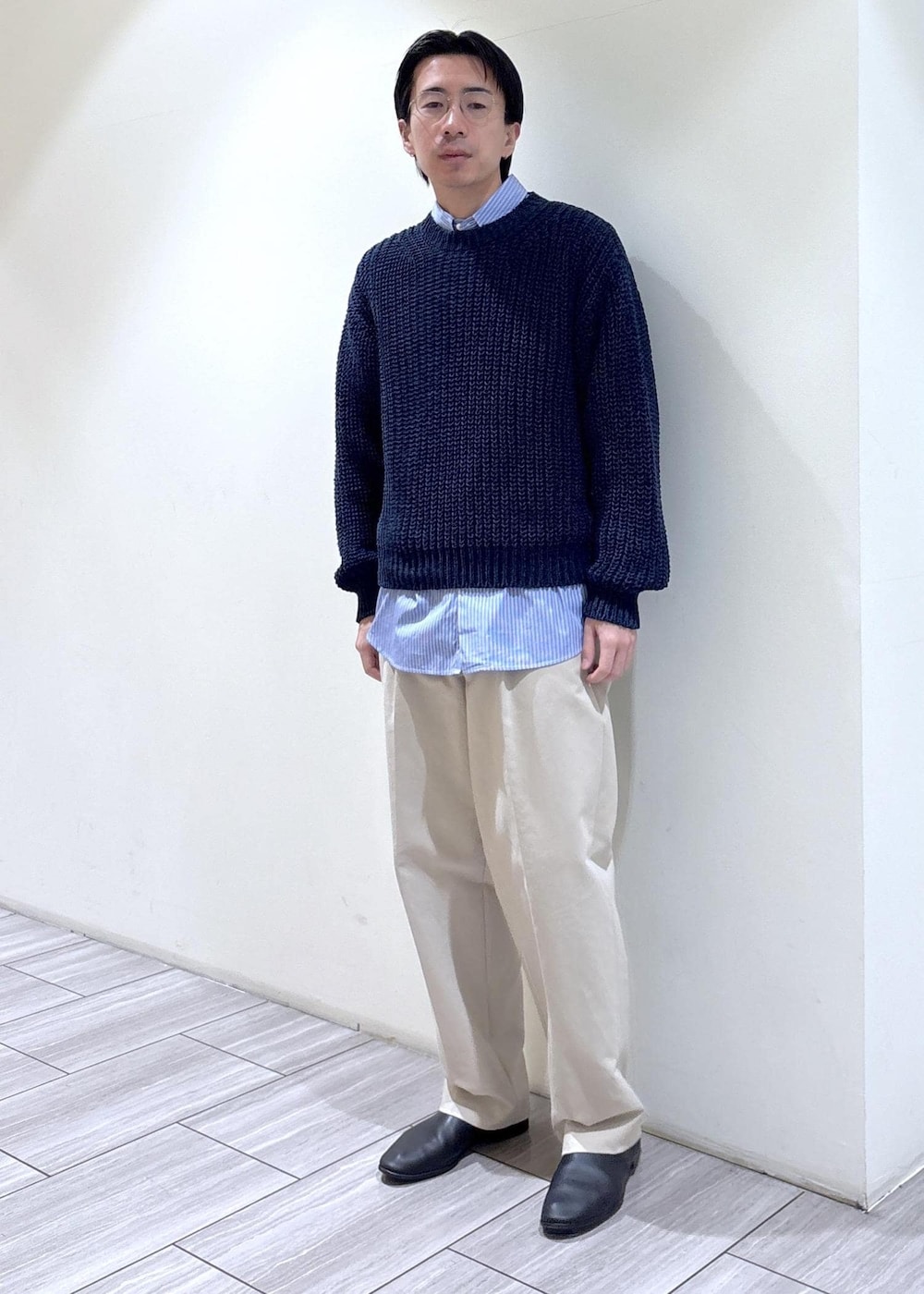 ブルー系のシャツ/ブラウス、ベージュ系のスラックス、ブルー系のニット/セーターを着用したメンズの春コーディネートの2枚目の写真