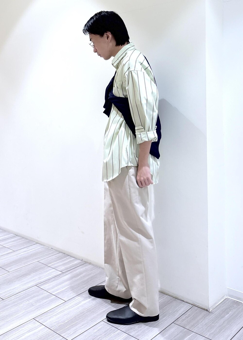 ブルー系のニット/セーター、グリーン系のシャツ/ブラウス、ベージュ系のスラックスを着用したメンズの冬コーディネートの3枚目の写真