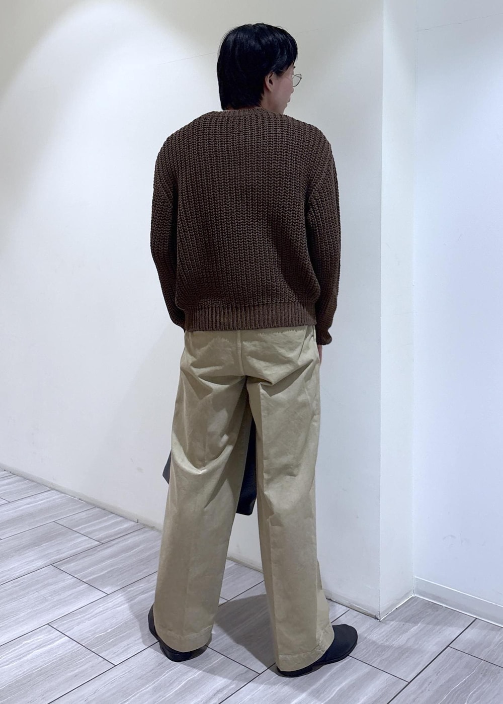 ブラウン系のニット/セーターを着用したメンズの春コーディネートの3枚目の写真