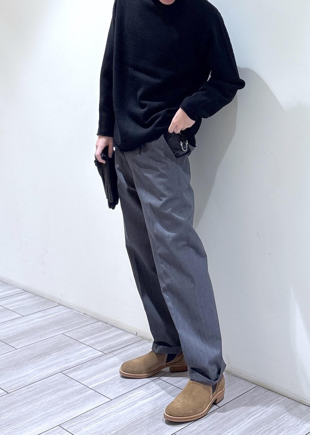 ブラック系のニット/セーター、グレー系のスラックスを着用したメンズの秋コーディネートの3枚目の写真