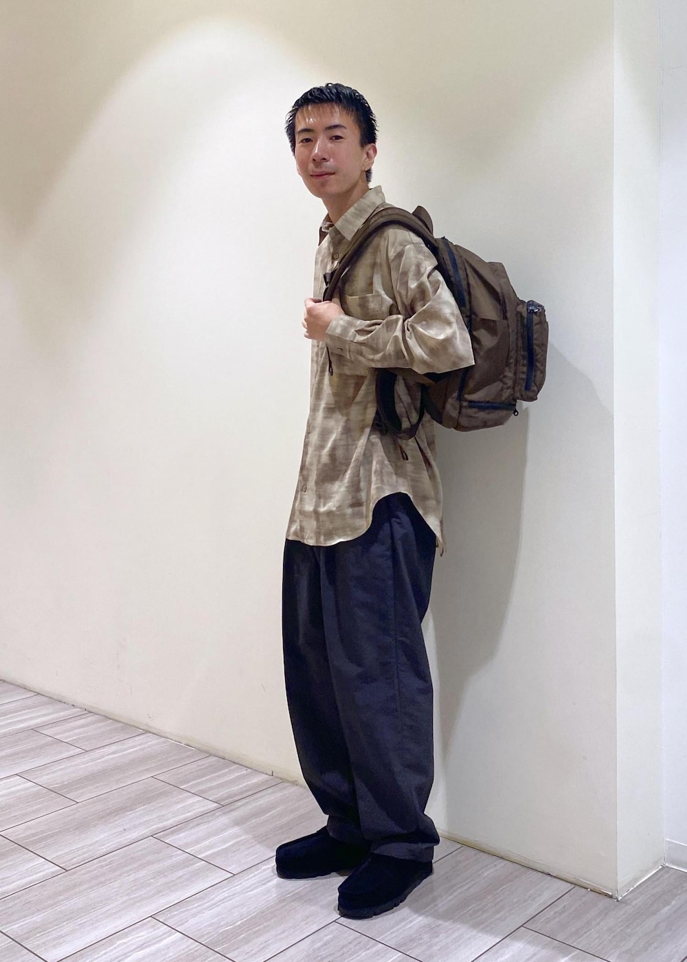 ブラウン系のバックパック/リュック、ベージュ系のシャツ/ブラウス、グレー系のその他パンツを着用したメンズの秋コーディネートの2枚目の写真