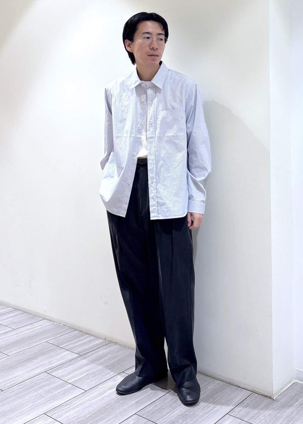 ブラック系のスラックス、ホワイト系のシャツ/ブラウスを着用したメンズの春コーディネートの2枚目の写真