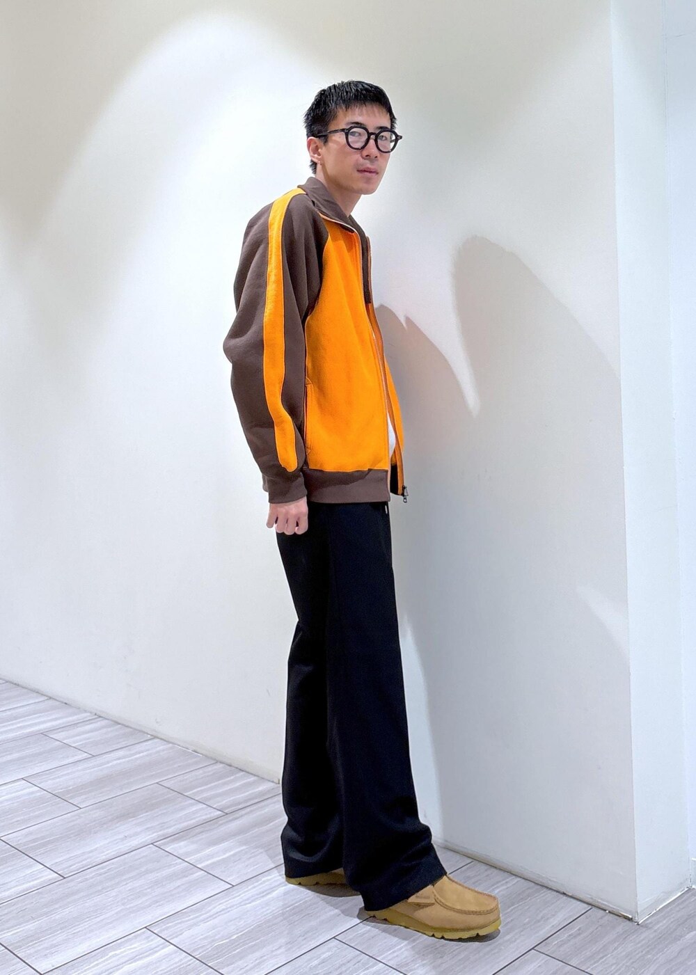 ブラウン系のカーディガン/ボレロ、ブラック系のスラックス、グレー系のスウェットを着用したメンズの秋コーディネートの3枚目の写真