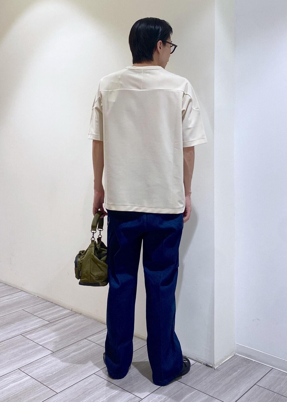 ブラック系のサンダル、ホワイト系のTシャツ/カットソー、ブルー系のカーゴパンツを着用したメンズの夏コーディネートの3枚目の写真