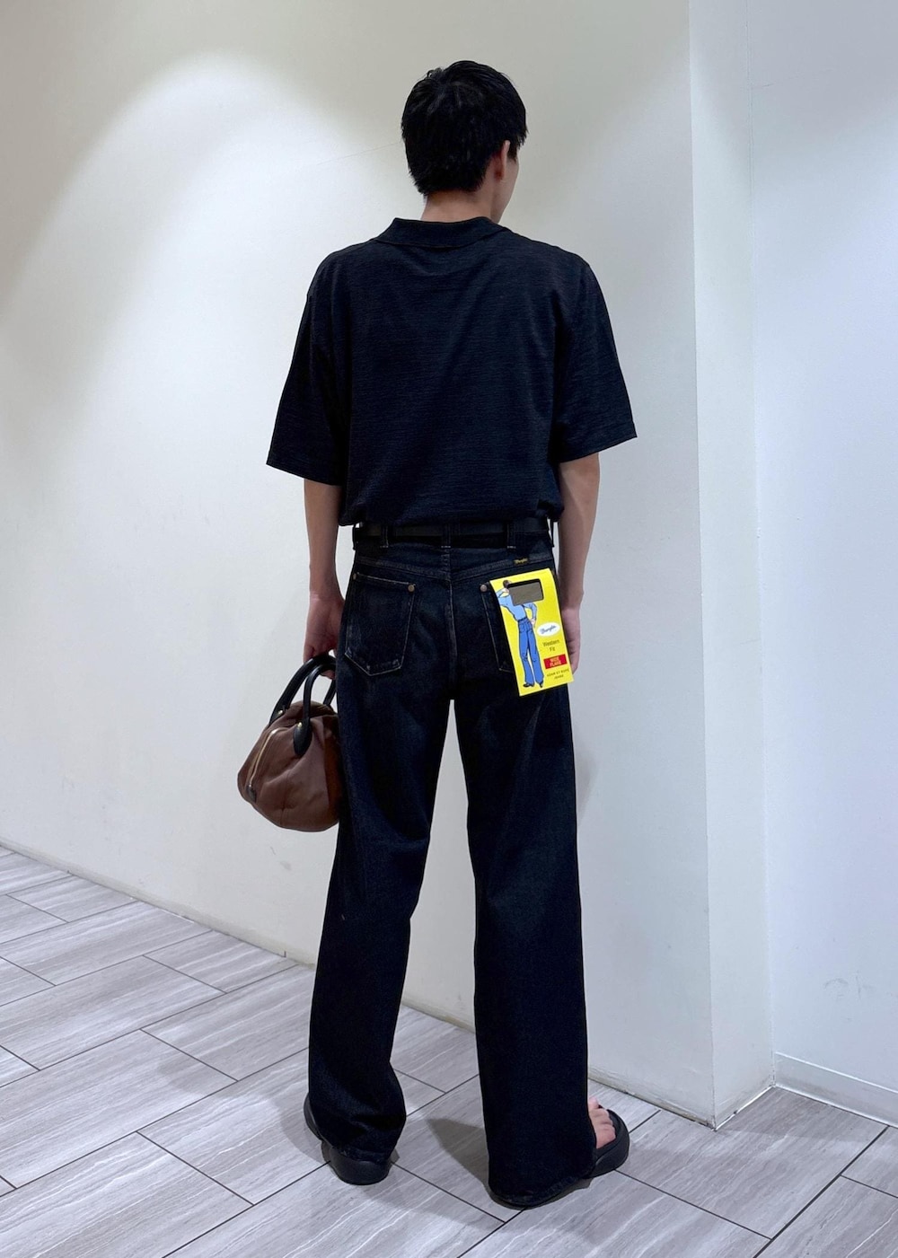 ブラック系のデニムパンツ、ブラック系のポロシャツを着用したメンズの夏コーディネートの3枚目の写真