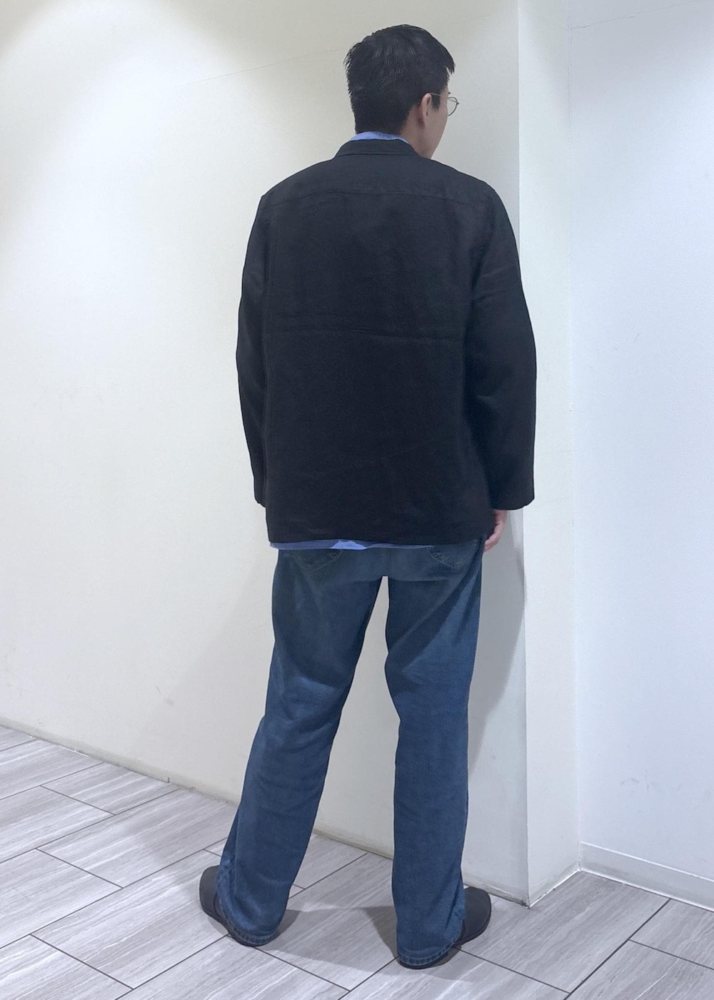 ブルー系のデニムパンツ、ブラック系のテーラードジャケットを着用したメンズの春コーディネートの3枚目の写真