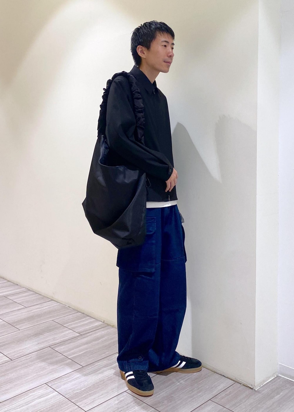 ブラック系のスニーカー、ブラック系のその他アウター、ブルー系のカーゴパンツを着用したメンズの秋コーディネートの2枚目の写真