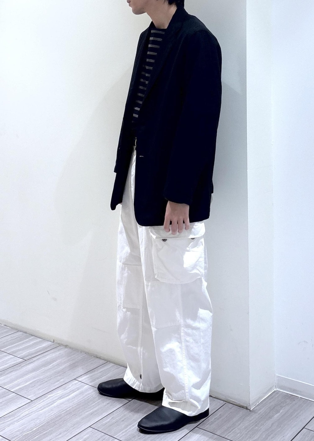 ホワイト系のカーゴパンツ、ブラウン系のTシャツ/カットソー、ブラック系のテーラードジャケットを着用したメンズの春コーディネートの2枚目の写真