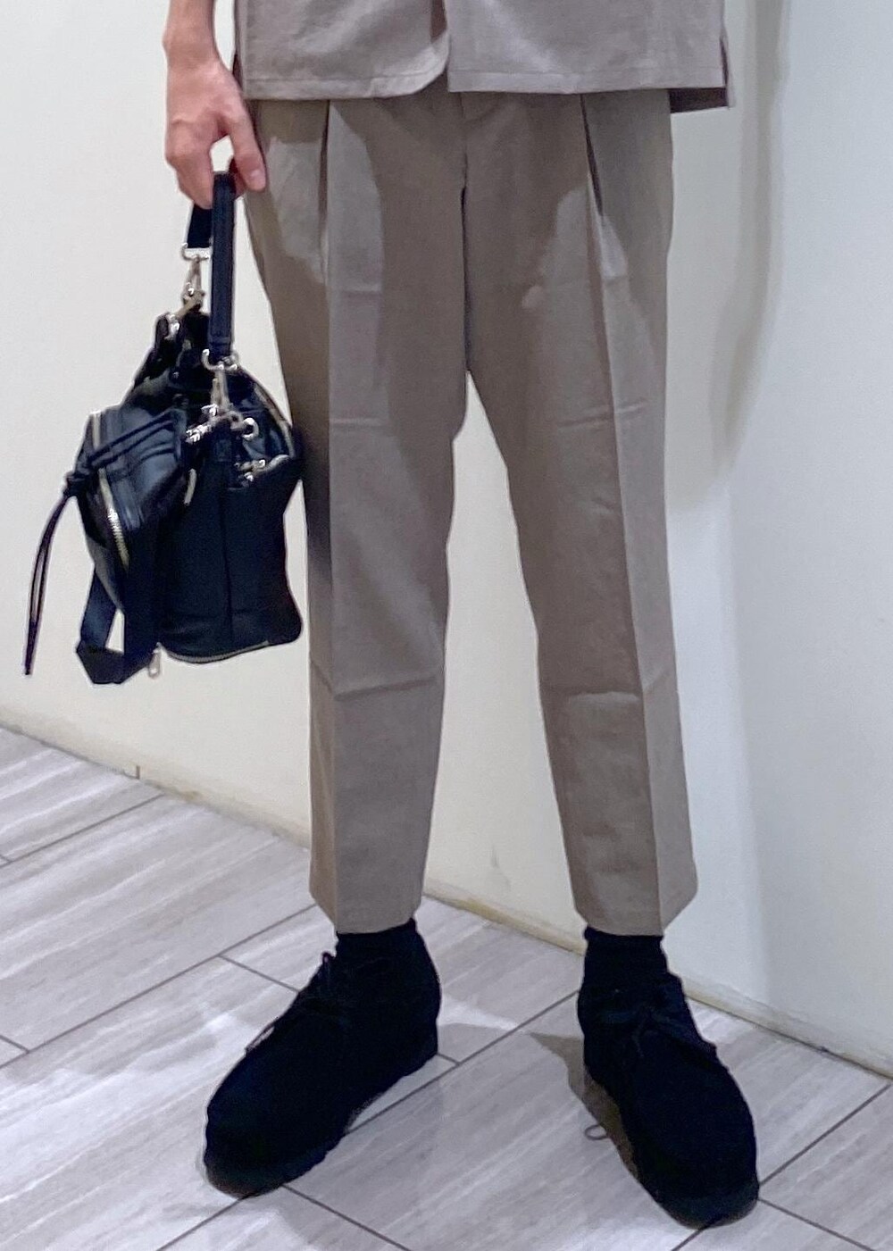 ベージュ系のセットアップ、ブラック系のTシャツ/カットソー、ブラック系のブーツを着用したメンズの夏コーディネートの7枚目の写真