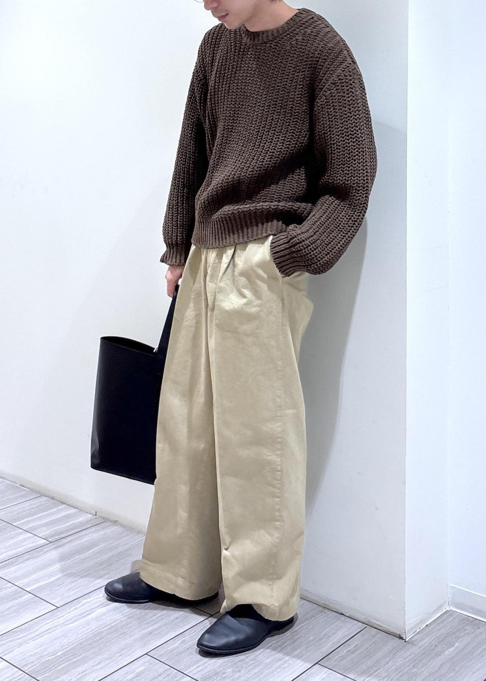 ブラウン系のニット/セーターを着用したメンズの春コーディネートの2枚目の写真