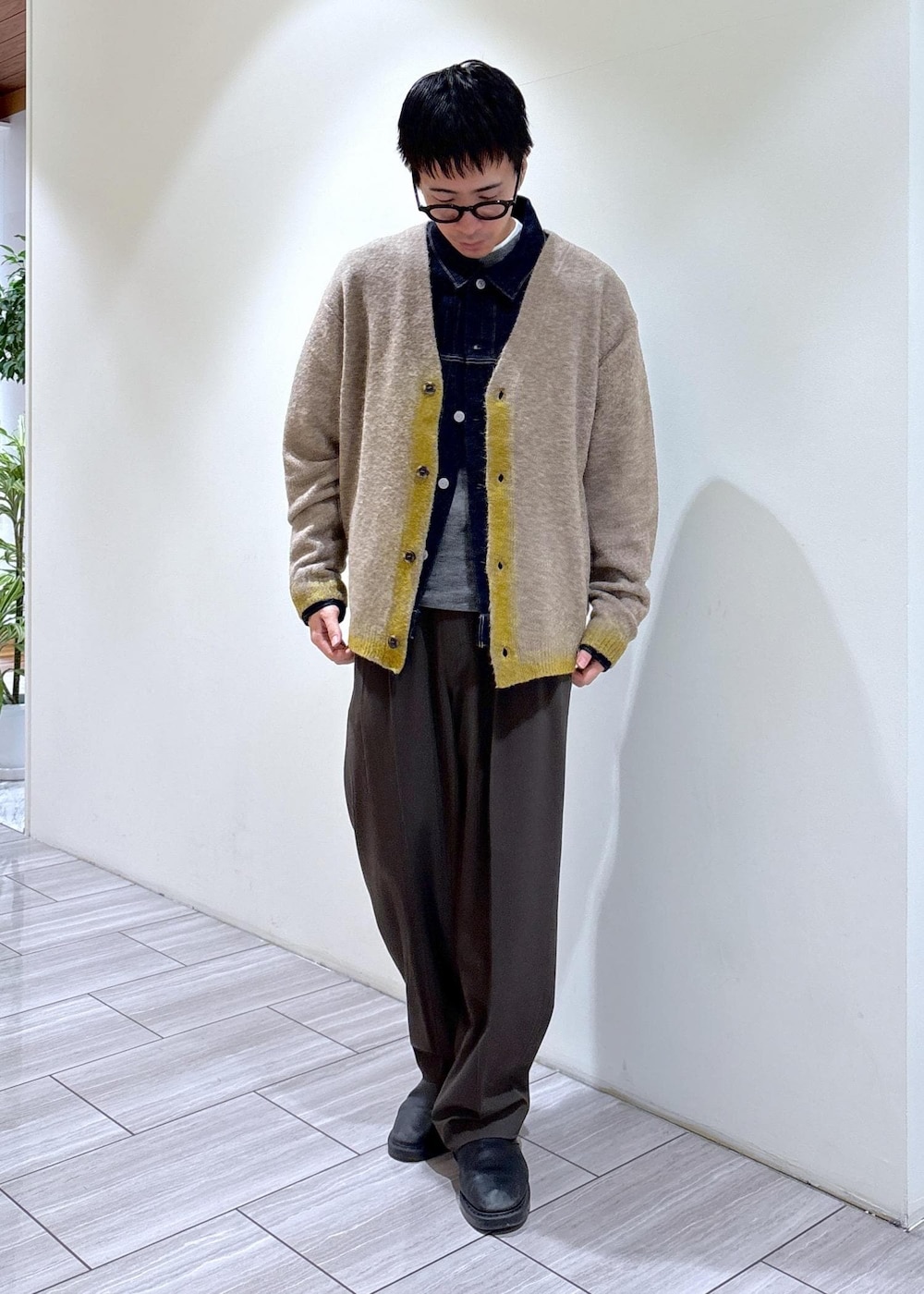 イエロー系のカーディガン/ボレロ、ブルー系のデニムジャケット、グレー系のニット/セーターを着用したメンズの秋コーディネートの3枚目の写真