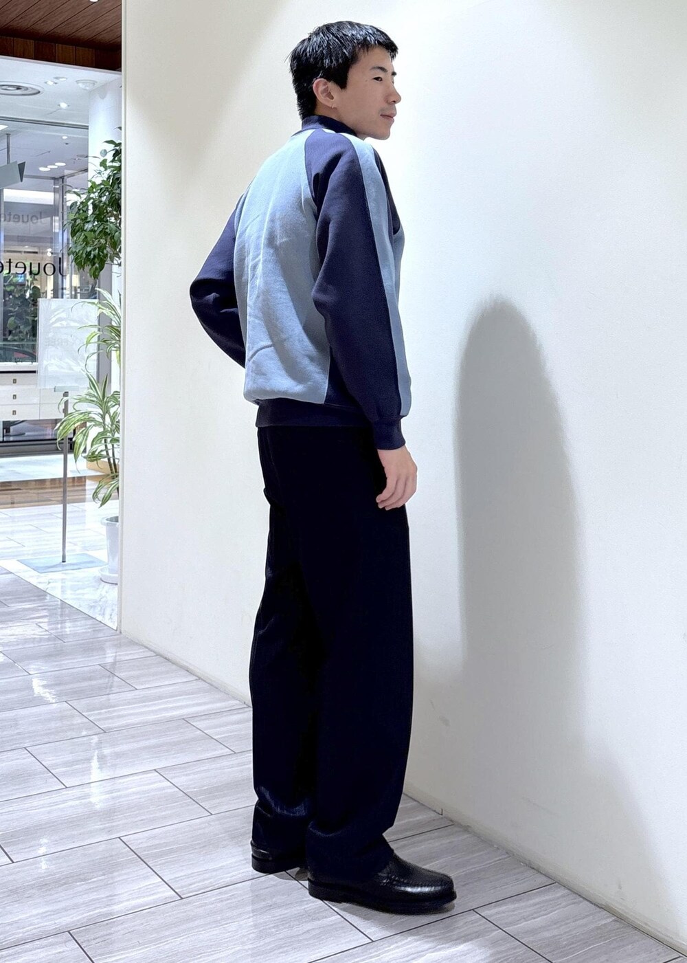ブラック系のスリッポン、ブルー系のカーディガン/ボレロ、ブルー系のスラックスを着用したメンズの秋コーディネートの3枚目の写真