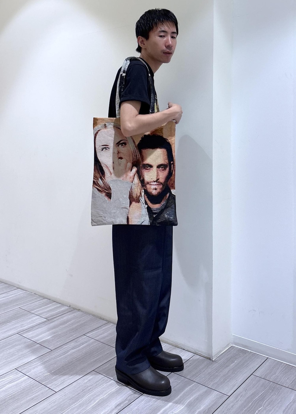 ブルー系のデニムパンツ、グレー系のTシャツ/カットソー、ベージュ系のトートバッグを着用したメンズの夏コーディネートの4枚目の写真