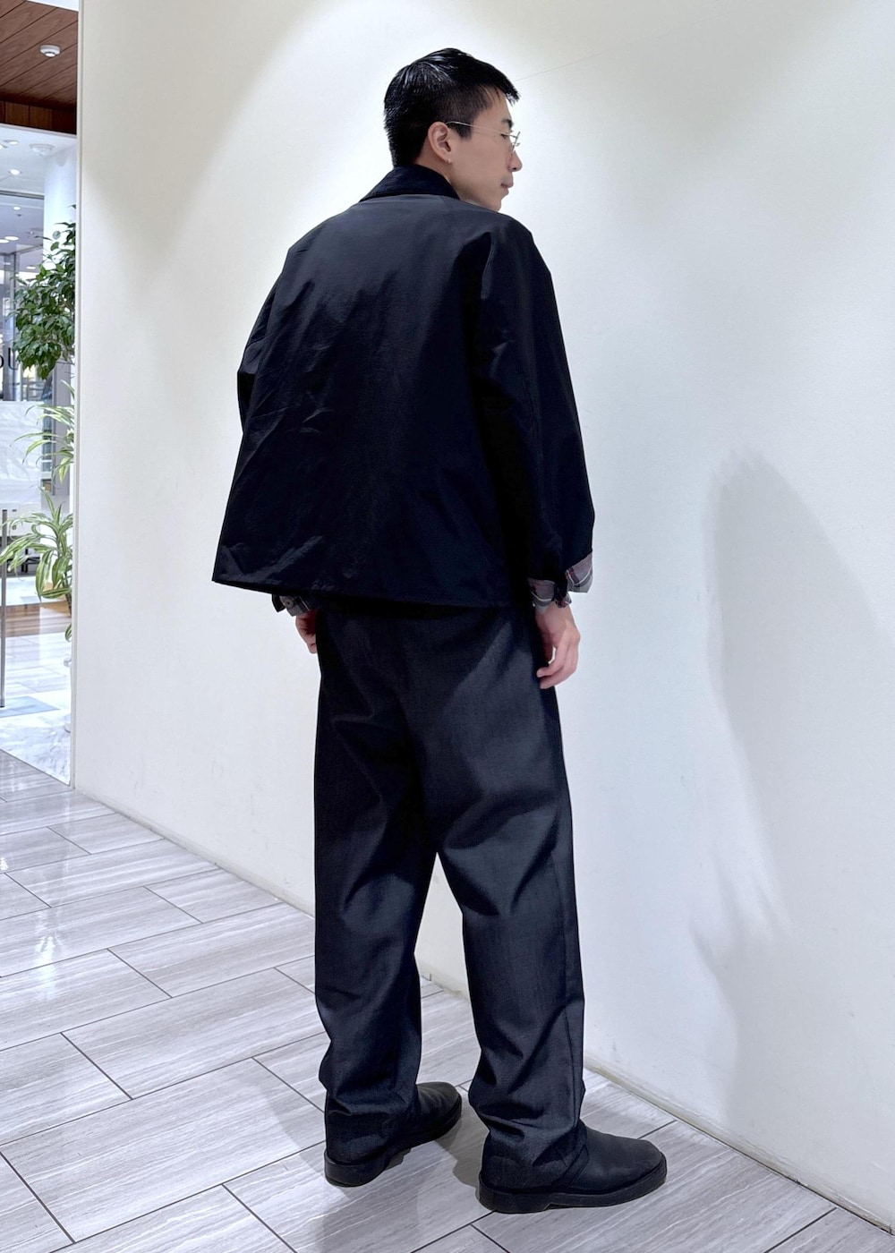 ブラック系のデニムパンツ、イエロー系のTシャツ/カットソー、ブラック系のブルゾンを着用したメンズの秋コーディネートの3枚目の写真