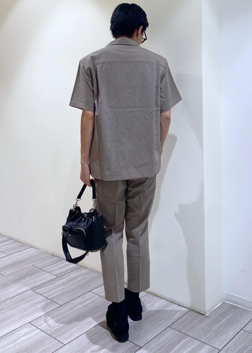 ベージュ系のセットアップ、ブラック系のTシャツ/カットソー、ブラック系のブーツを着用したメンズの夏コーディネートの3枚目の写真