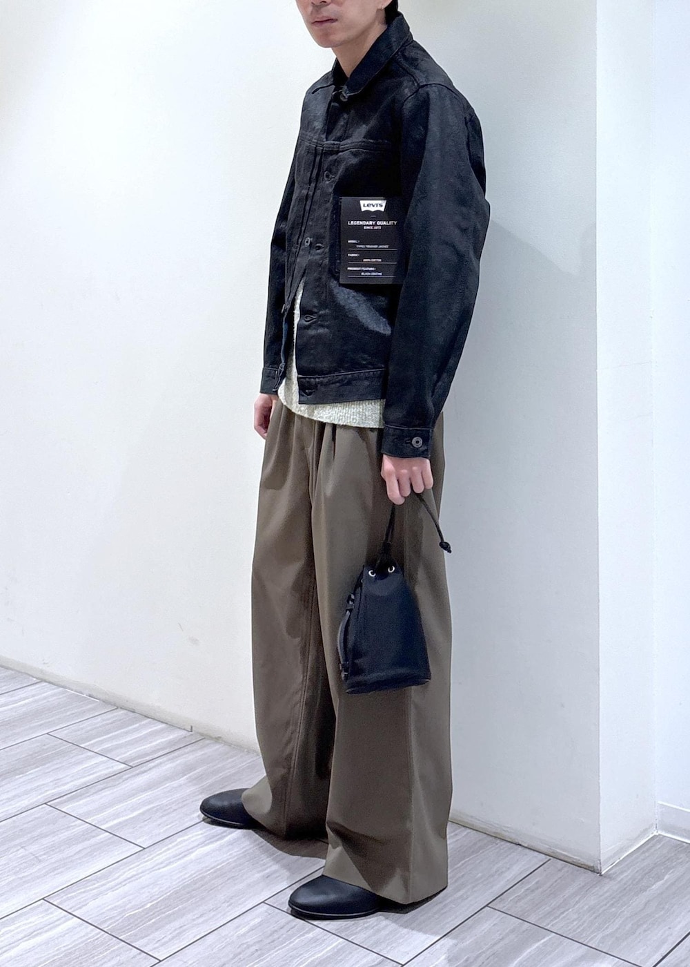 イエロー系のニット/セーター、グリーン系のその他パンツを着用したメンズの冬コーディネートの2枚目の写真